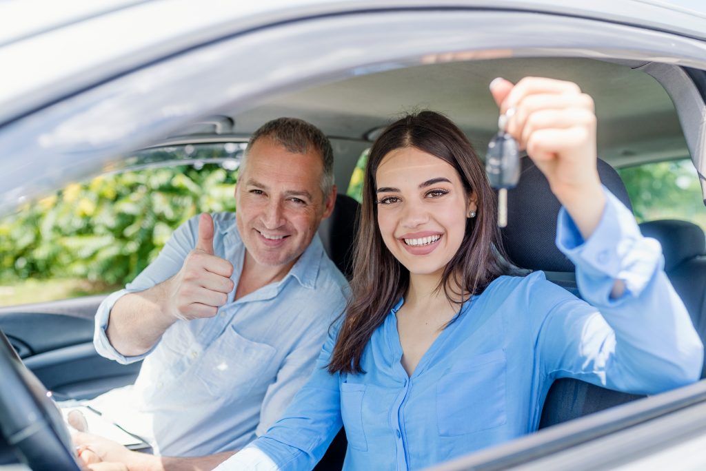Retired client with daughter in car smiling