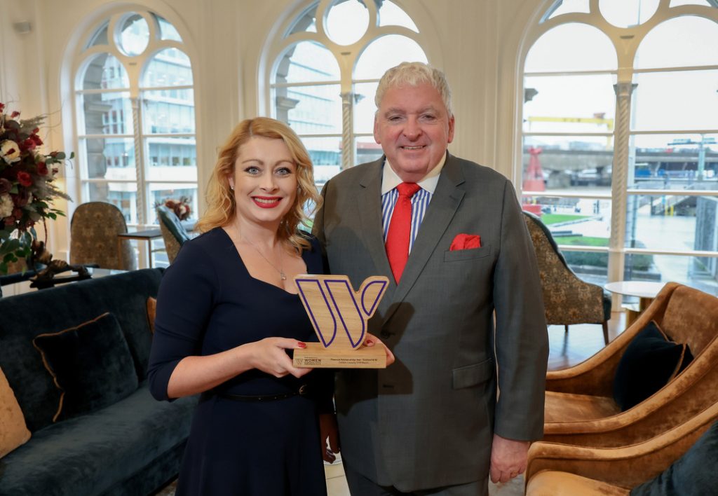 Debbie Connolly and Feargal McCormack smiling at camera holding award