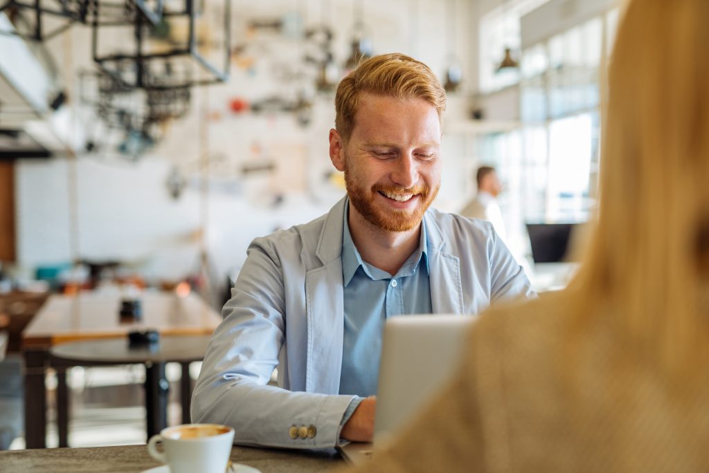 Scottish young professional, smiling whilst having a coffee with colleague