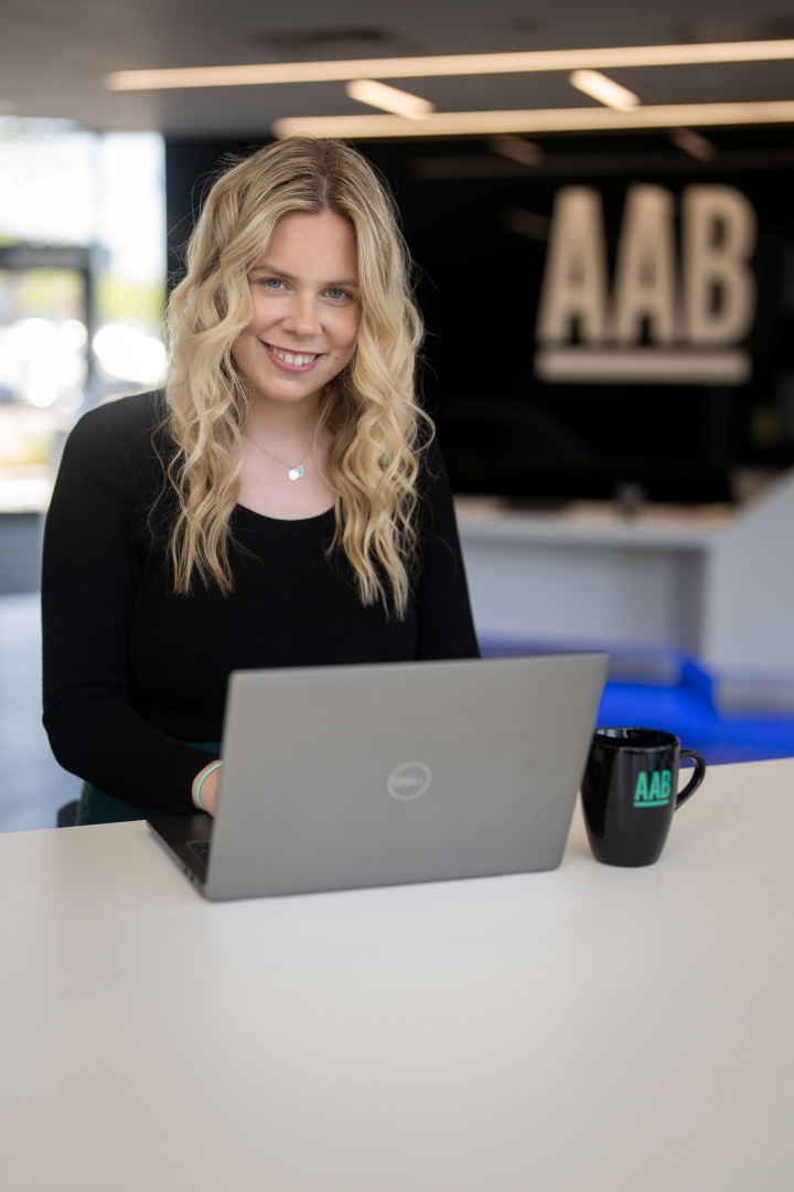 Kate Henry standing at office table on laptop