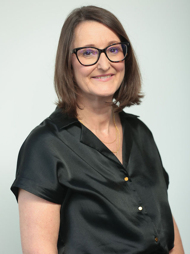 An image of Francesca Powell wearing a black top and smiling at th camera.