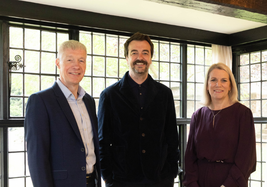 An image of Simon Brown, Andrew Dines and Nicola Watts standing in a building smiling at the camera.