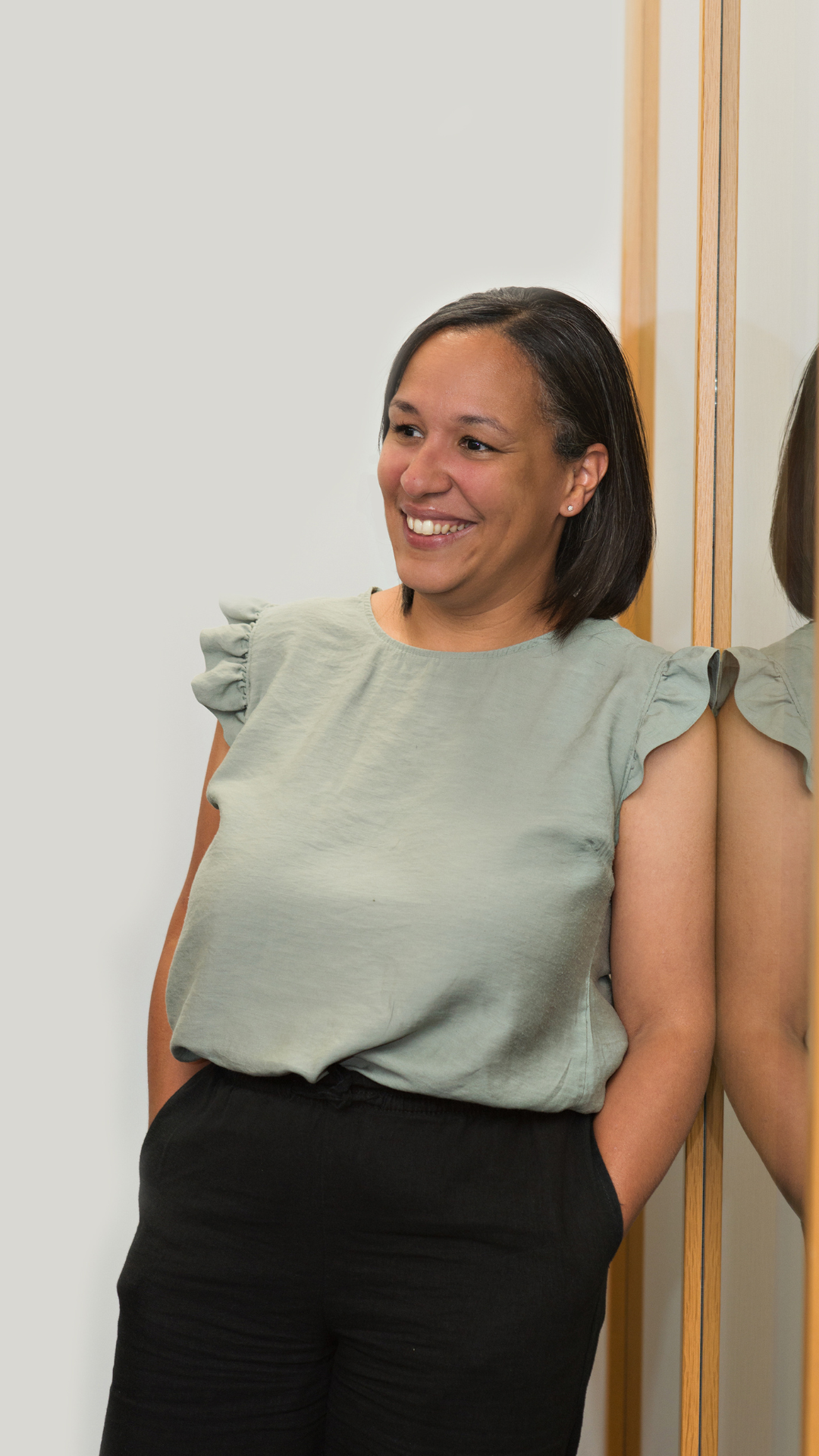 Lauren Jones, Technical Specialist at AAB Wealth, leaning up against a wall and mirror